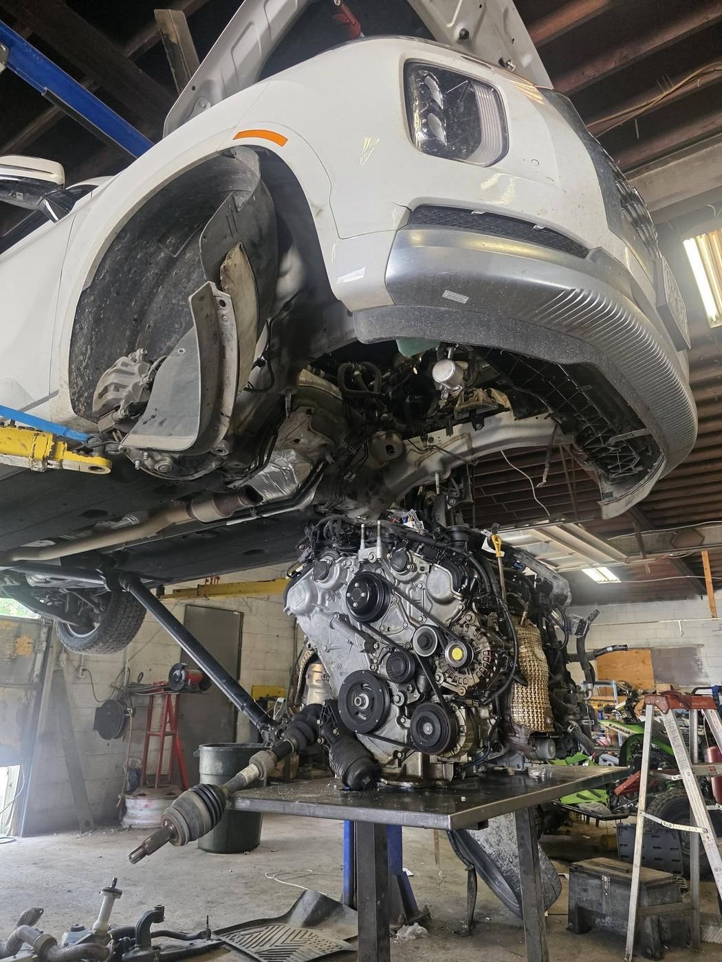 Engine and subframe staged on the table, ready to come apart.