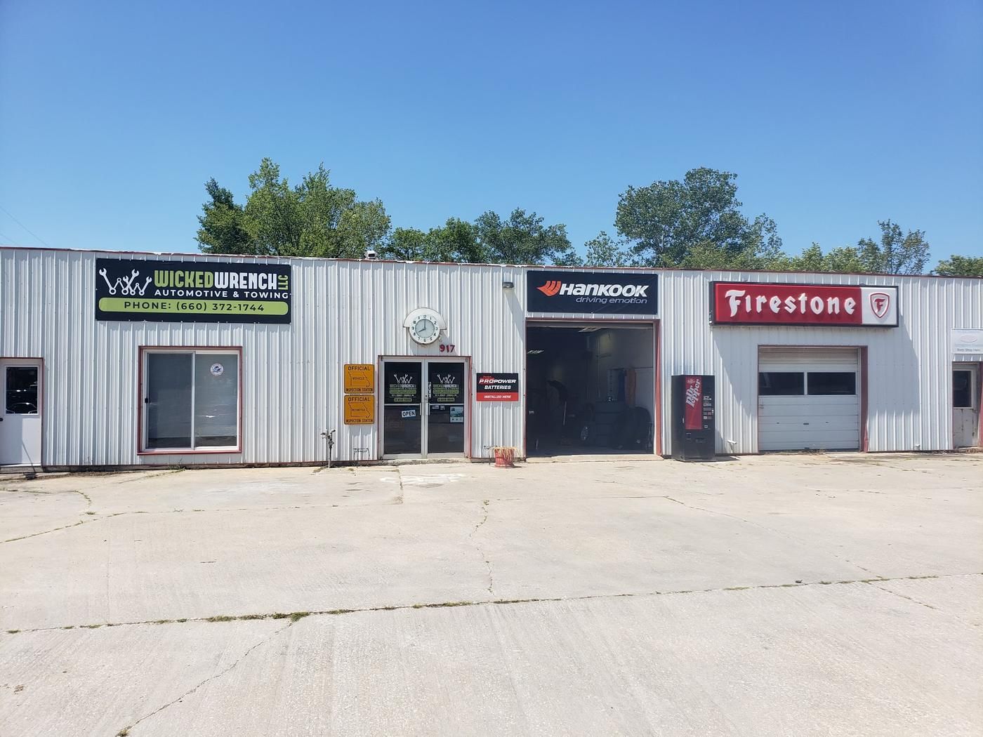 Wicked Wrench storefront on S Morley St with official Missouri inspection station signs and an open service bay