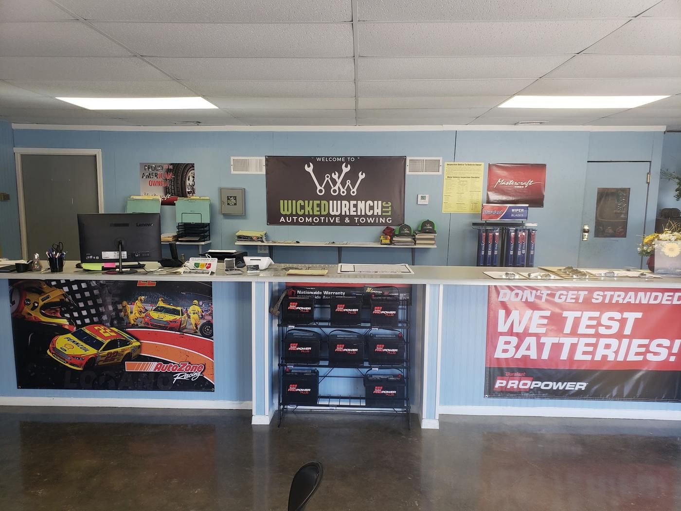 Front office at Wicked Wrench with the shop banner, battery display and service counter
